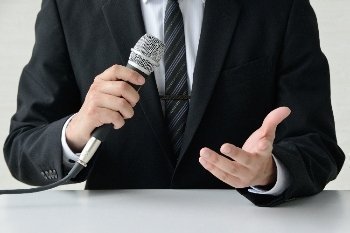 Hombre de traje sosteniendo micrófono