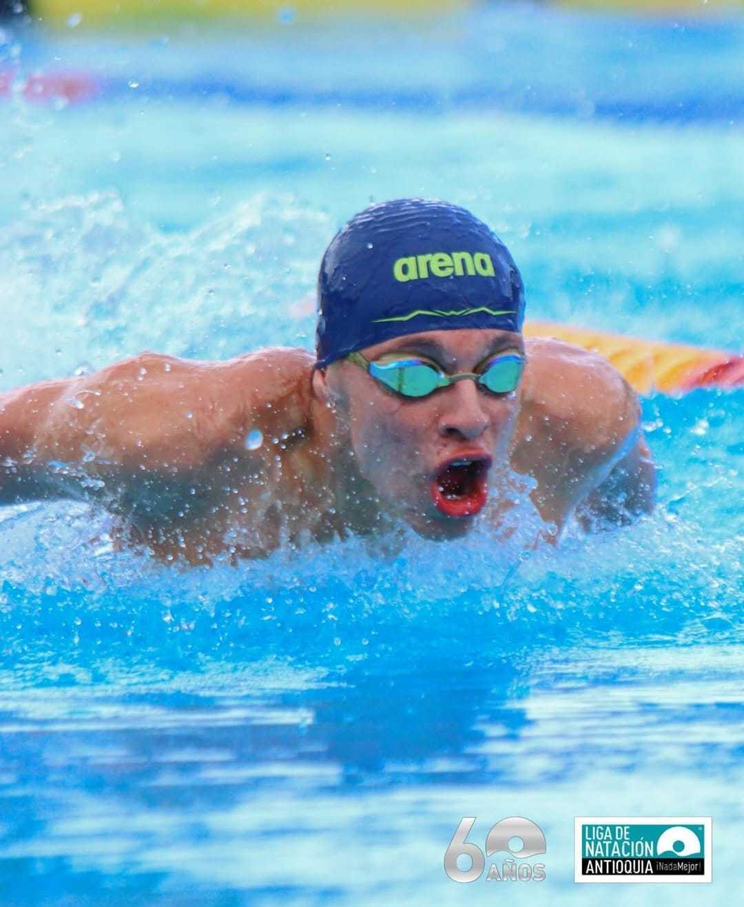 Un nadador compitiendo en una carrera de estilo mariposa.