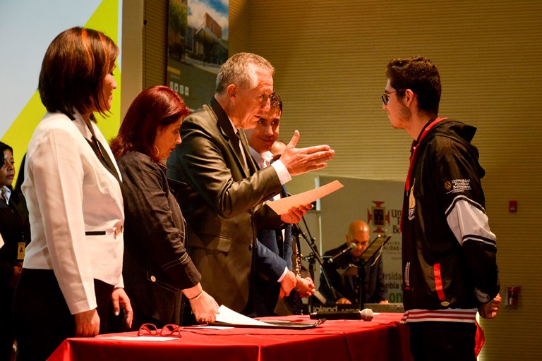 El rector del Colegio Ómar Peña Muñoz entregando un reconociemiento especial.