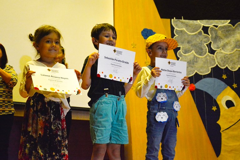 Los niños y niñas sonriendo por sus reconocimientos.