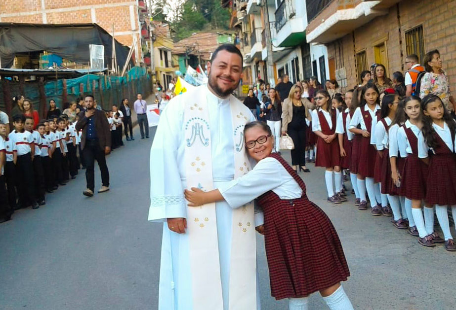 Aquí está el Padre Daniel Felipe Cardona Salazar y la estudiante 