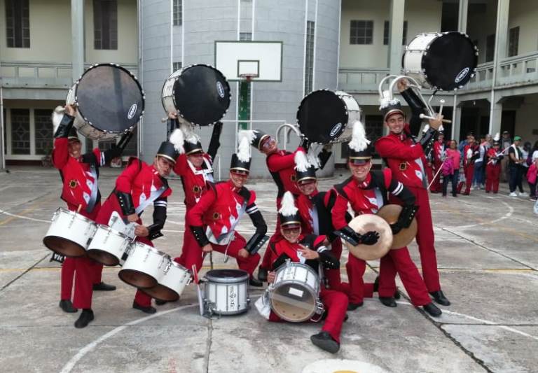 Algunos jóvenes de la banda que tocan instrumentos de percusión.