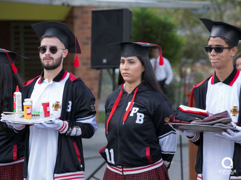 Estudiantes entregando los implementos de estudio como símbolo Institucionales.