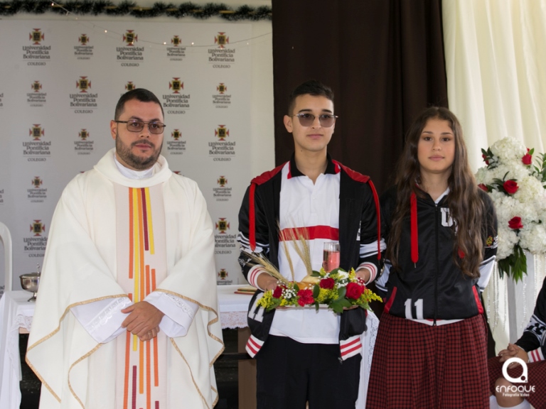 Pbro. Mg. Daniel Felipe Cardona Salazar junto a dos estudiantes de once en la Eucaristía en Acción de gracias.