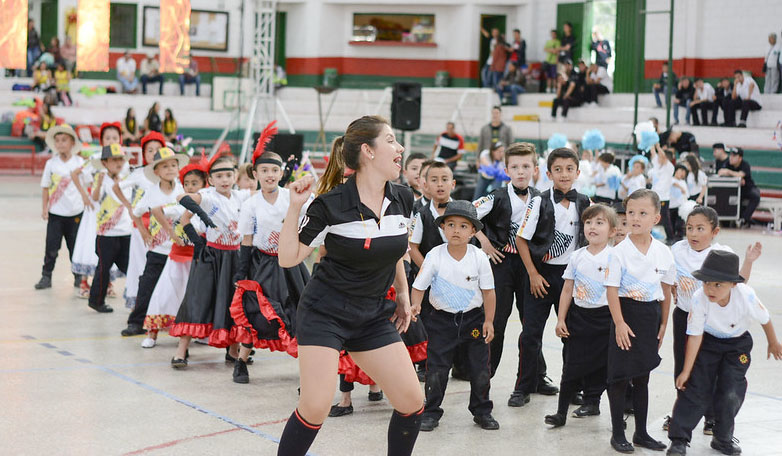 La docente Juliana Gómez y sus estudiantes de preescolar durante las coreografías de la inauguración de los Juegos Interclases