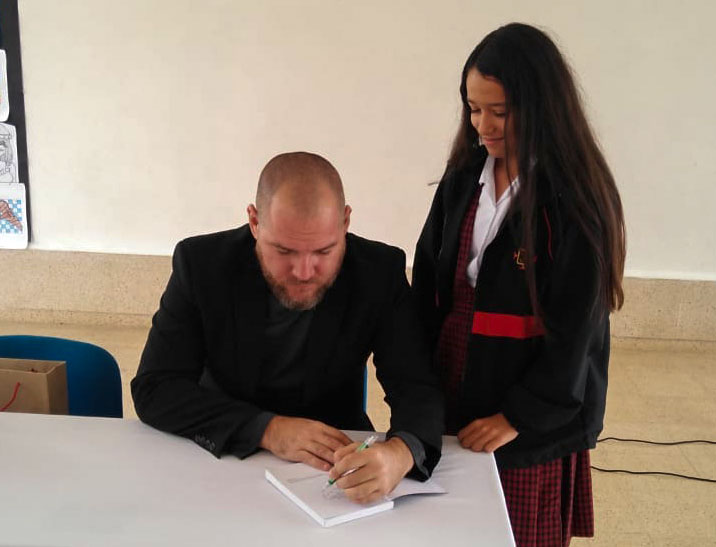 El escritor Maikel Rodríguez firmando autógrafos.