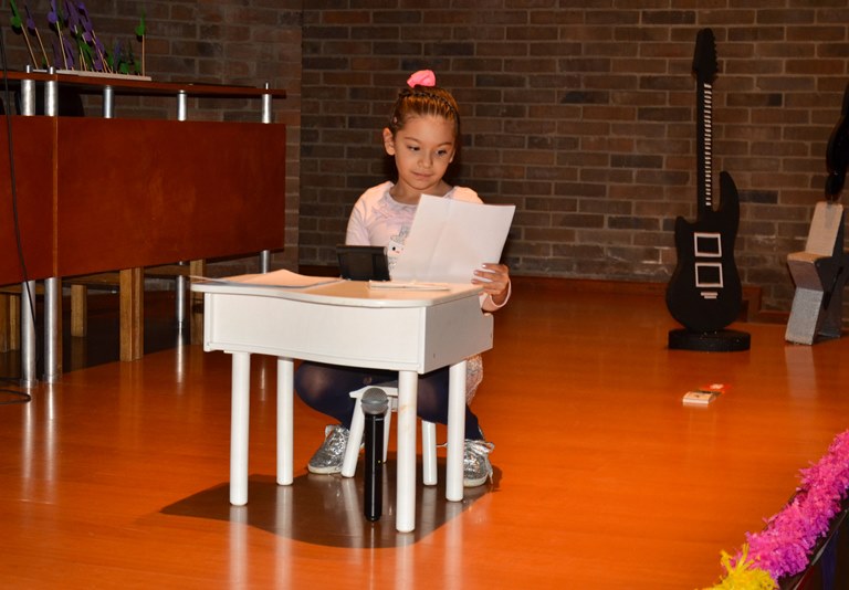 Niña tocando su pequeño piano en el festival de talentos