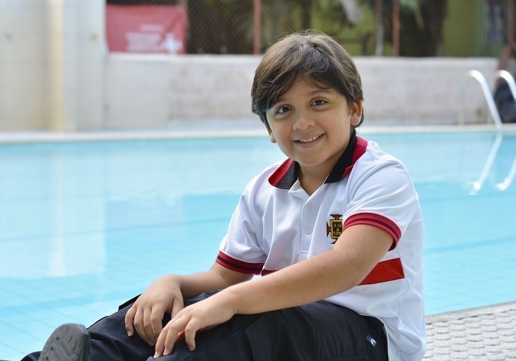 Ganador de medalla oro y plata del grado cuarto mirando a la cámara, sonriendo.