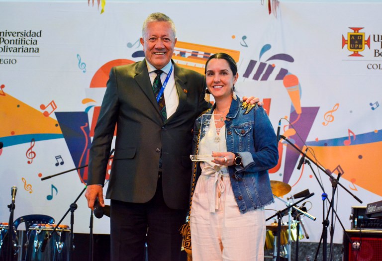  El rector, Ómar Peña Muñoz entregandole reconocimiento a Natalia Mejía Gómez, directora de mercadeo del centro comercial Los Molinos.