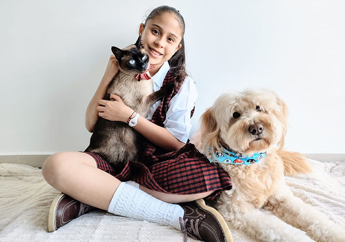 La estudiante Valentina Ruíz Velazco junto a su gato Blue y su perro Peluche.