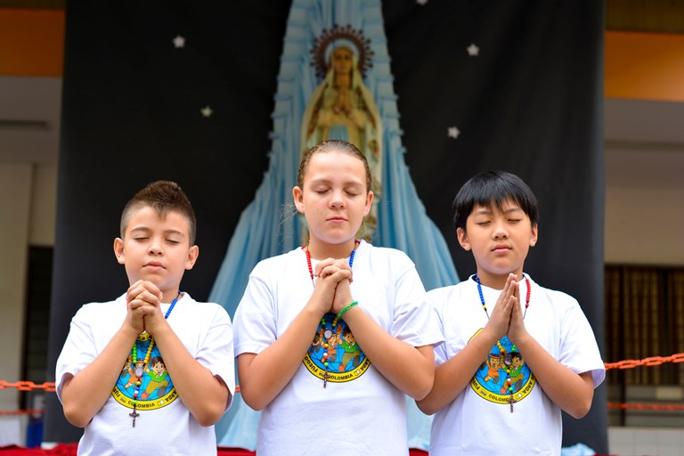 Infancia Misionera en el altar a la Virgen María en el patio de Primaria