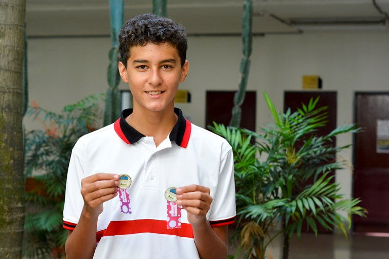 Aquí está el estudiante Juan Manuel Lopera Zuluaga mostrando las dos medallas que ganó en el Festival Nacional de Interclubes de Natación 