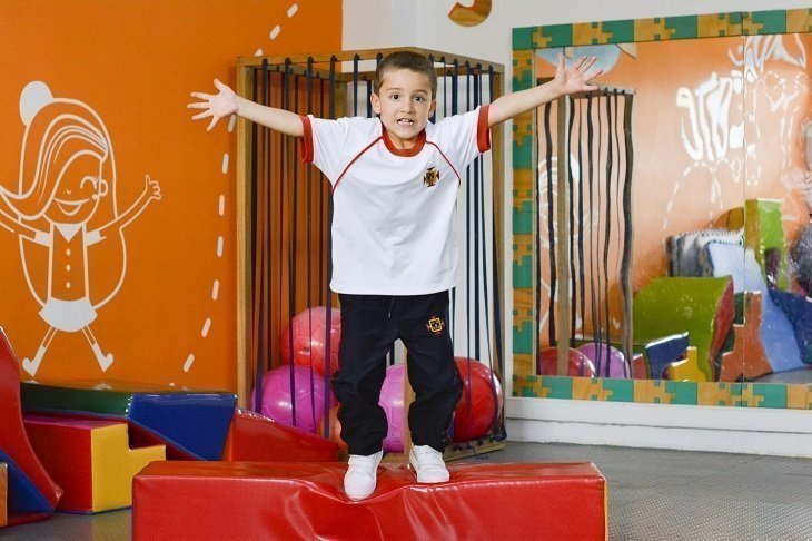 Niño en el aire con uniforme del colegio UPB