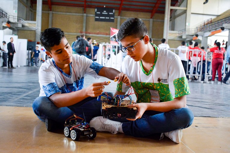Estudiantes con su robot previo a la competencia de FolkRace en Robotex LatAm