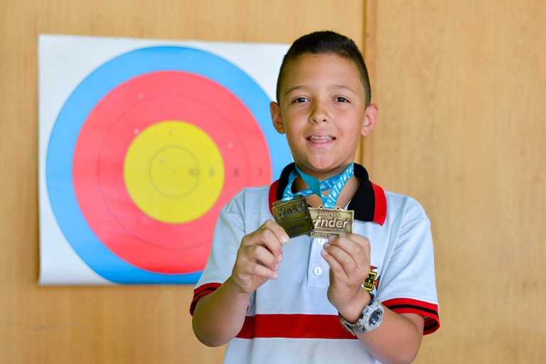 Simón Cano exponiendo las medallas de primer lugar que obtuvo en campeonatos Intercolegiado y EDP.