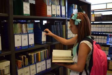 Chica buscando libro en estante