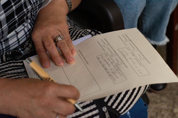 Mujer escribiendo con un lápiz en una hoja