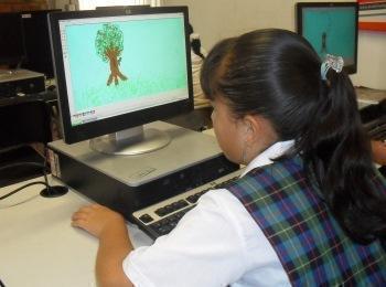 niña de colegio dibujando en un computador 