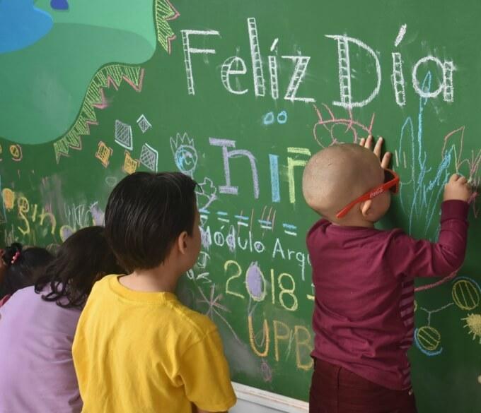 Niños dibujando en el nuevo tablero de la Clínica Noel