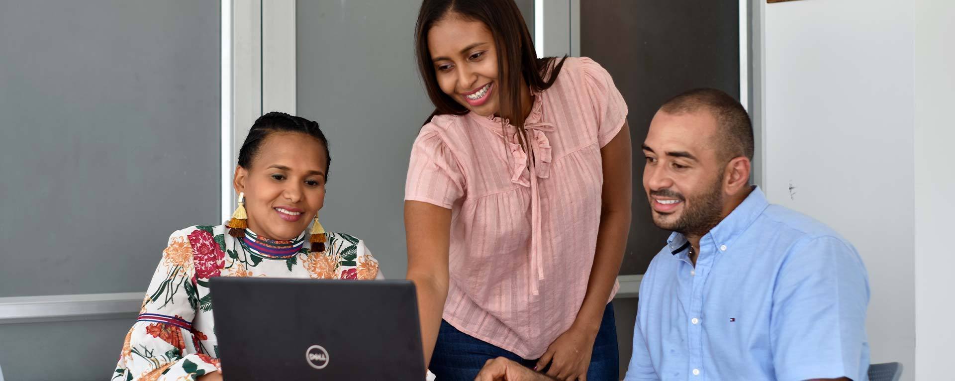 Estudiantes de postgrado comparten frente a computador portátil 