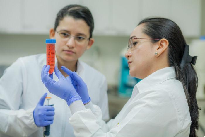 Dos investigadoras observando un tubo de ensayo