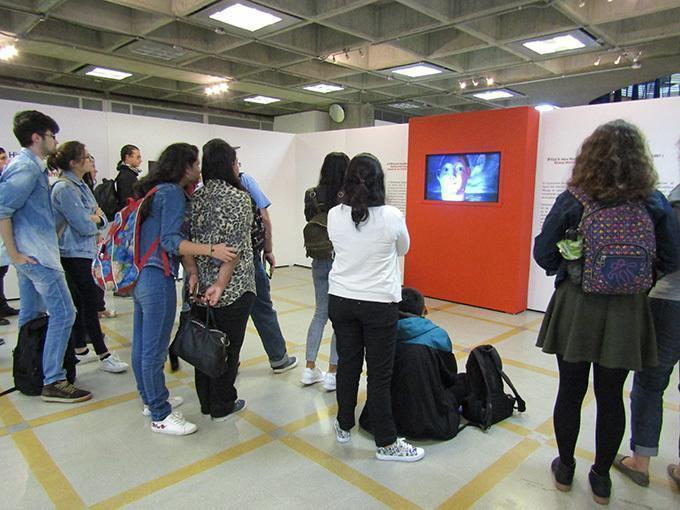 Un grupo de estudiantes se encuentran observando la exposición de los videoartistas de Japón