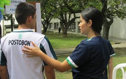 Estudiante con fisioterapeuta evaluando la postura