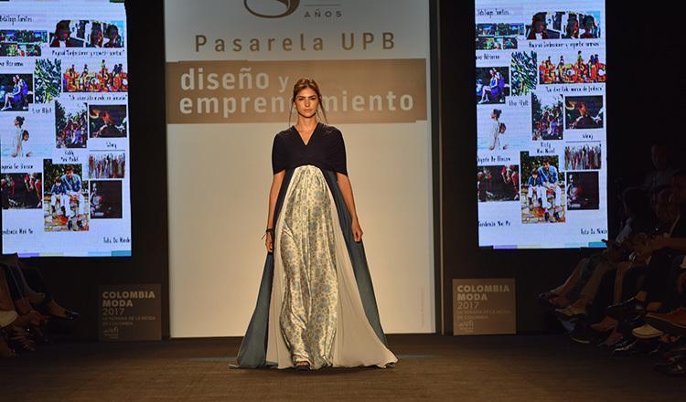 Modelo en la Pasarela UPb en Colombiamoda. Al fondo, en el backing pasarela y emprendimiento.