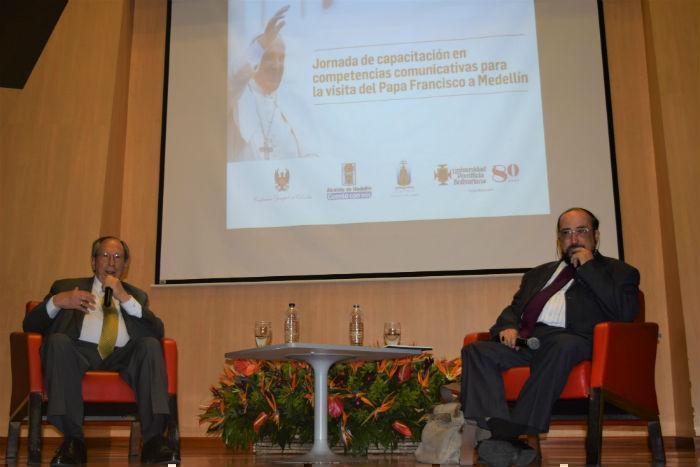 Juan Gómez Martínez y Guillermo León Escobar sentados en el escenario del Aula Magna de la UPB dictando una conferencia