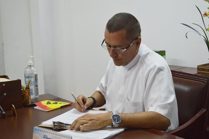 Padre Julián sentado en su escritorio escribiendo