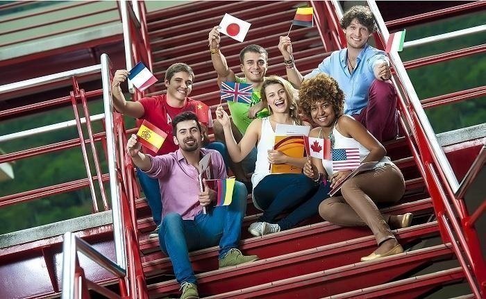 estudiantes en escaleras con banderas de diferentes países
