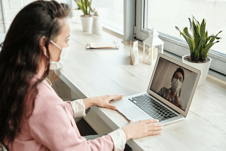 Mujer con tapabocas en el pc