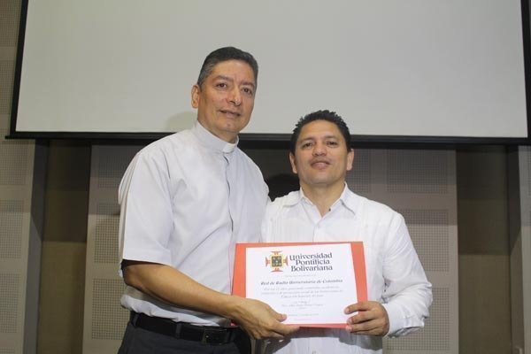 El Rector de UPB Montería, Pbro. Jorge Alonso Bedoya Vásquez, entregó reconocimiento e impuso el Escudo Bolivariano al presidente de la RRUC, Eliher Hernández.