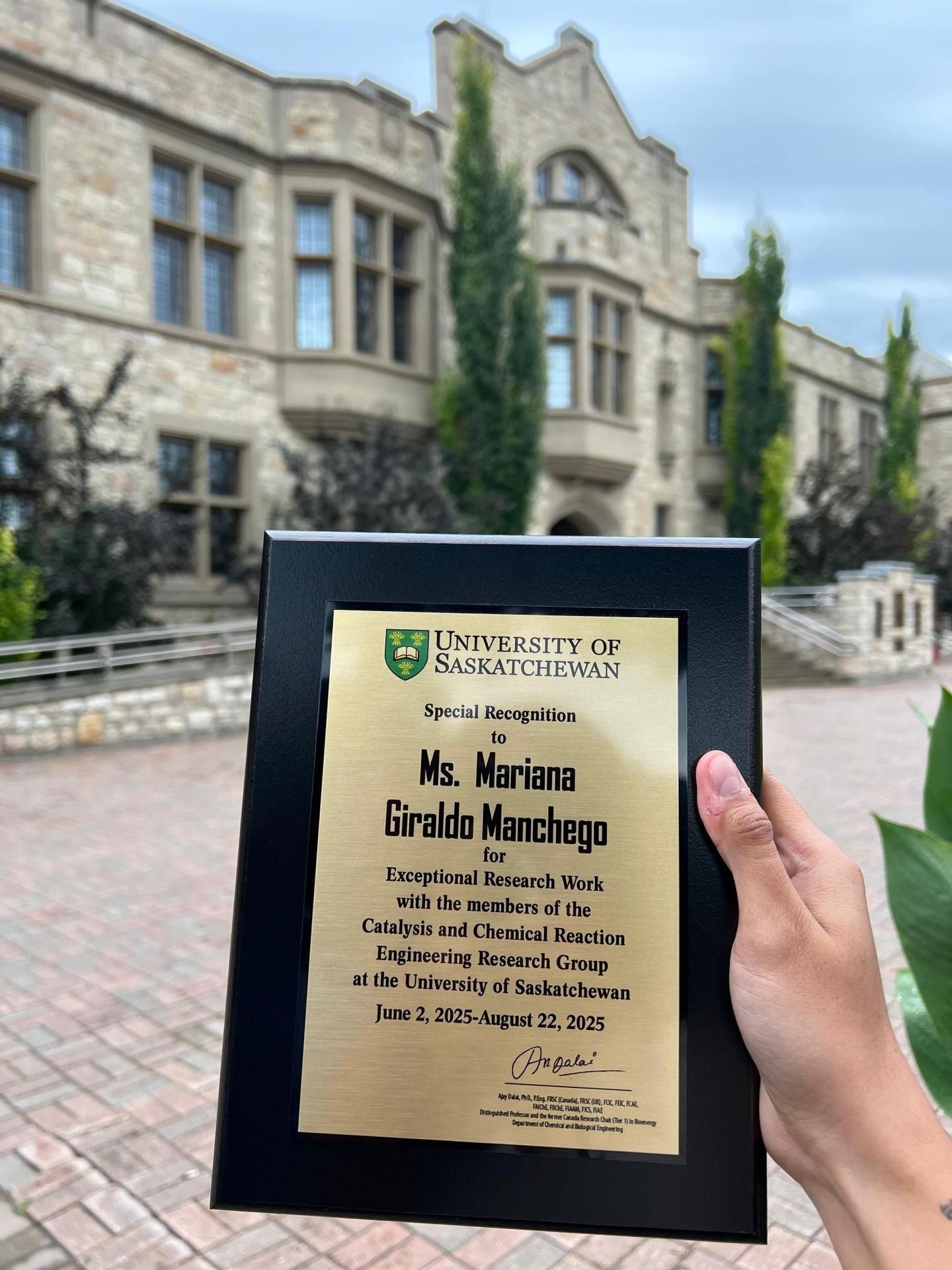 Mariana sosteniendo su reconocimiento por hacer su pasantía en la Universidad de Saskatchewan