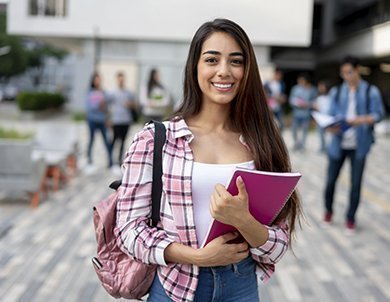 estudiante con cuaderno sonriendo