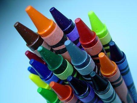 Sobre una superficie azul clara, se encuentran varios crayones de diferentes colores.