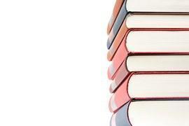 Siete libros de biblioteca se encuentran uno encima de otro.