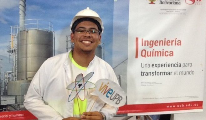 Estudiante sosteniendo premio, al fondo se ve poster de ingeniería química