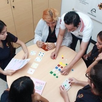 Estudiantes realizando dinámicas alrededor de una mesa