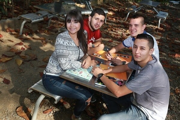 Estudiantes sentados en una mesa departiendo juntos