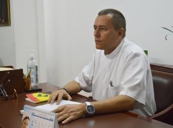 Padre Julián sentado en su escritorio, de perfil