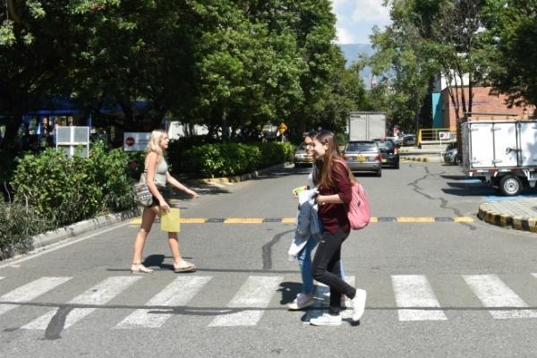 Personas cruzando la calle por una zebra en el campus Laureles