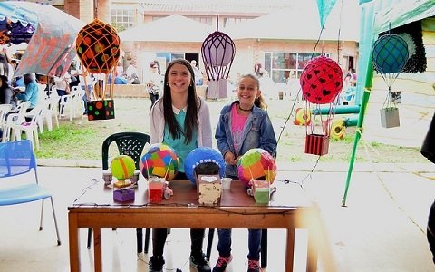 Dos niñas jóvenes atendiendo un puesto de venta de decoración